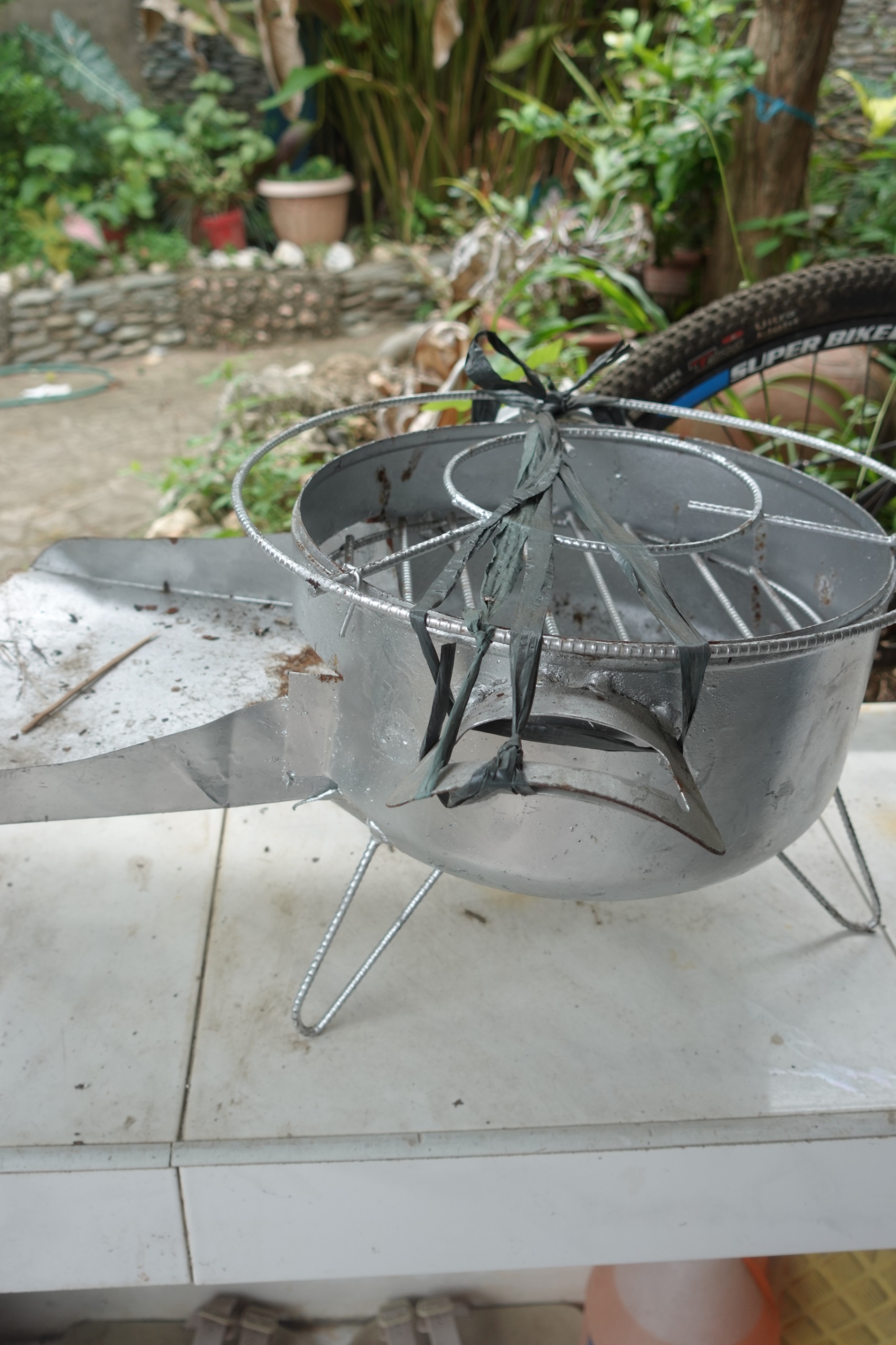 Used metal charcoal stove with grill and rebar legs